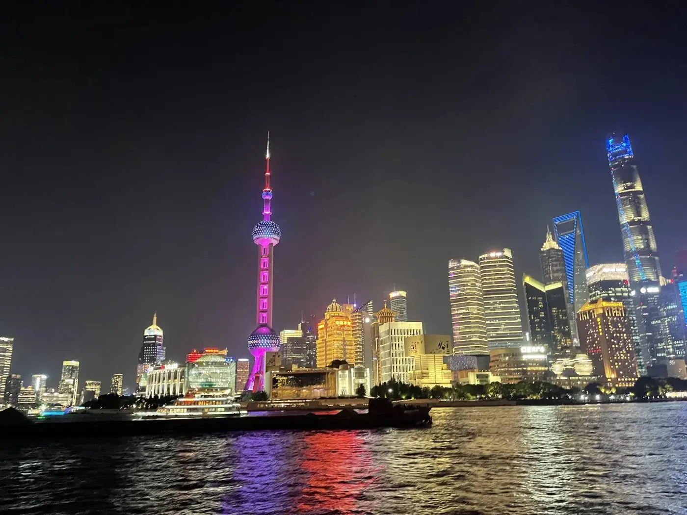 Oriental Pearl Tower and Lujiazui skyline lit up at night from the Huangpu River